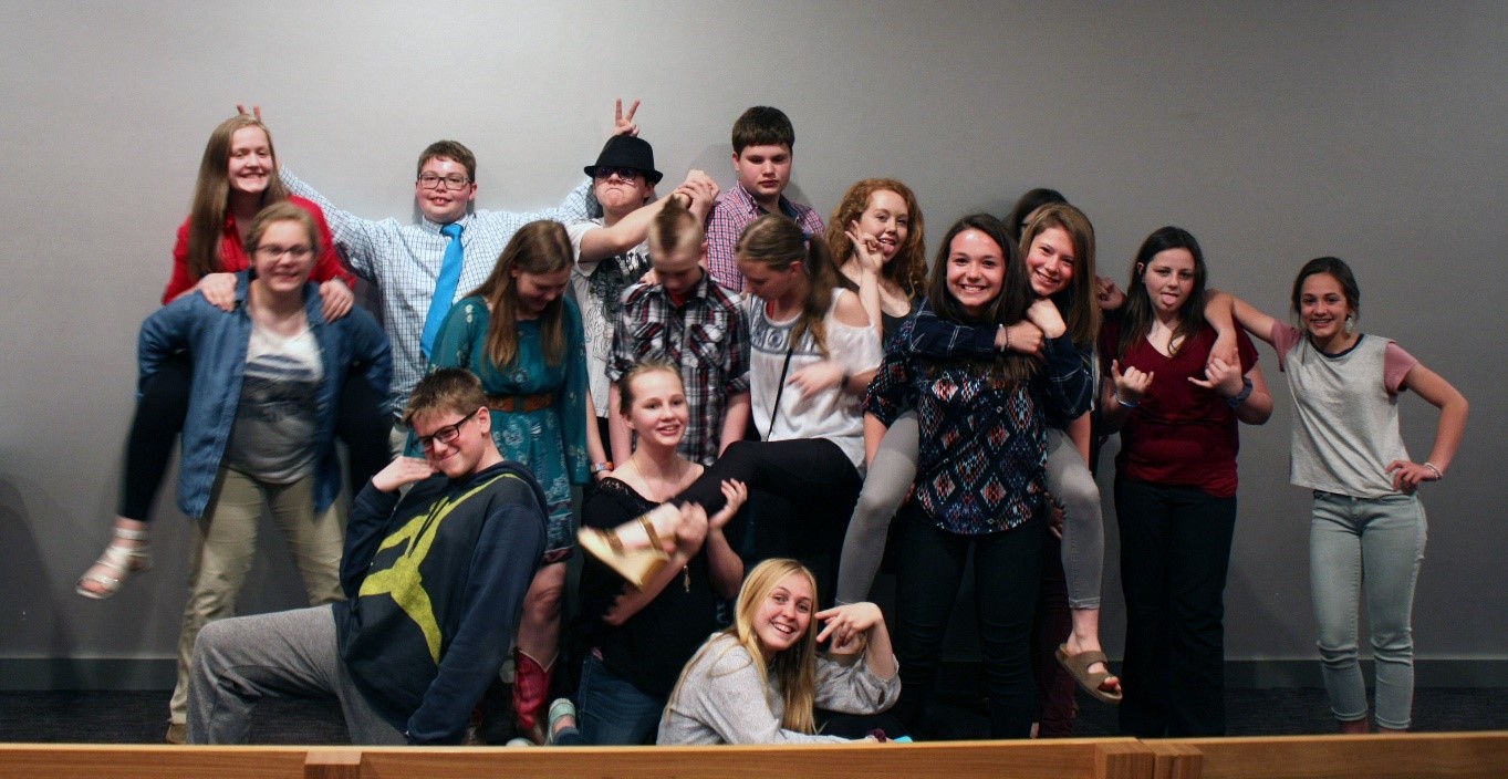 image is of National History Day students from 2018. The students are posing in a fun and silly postures. 